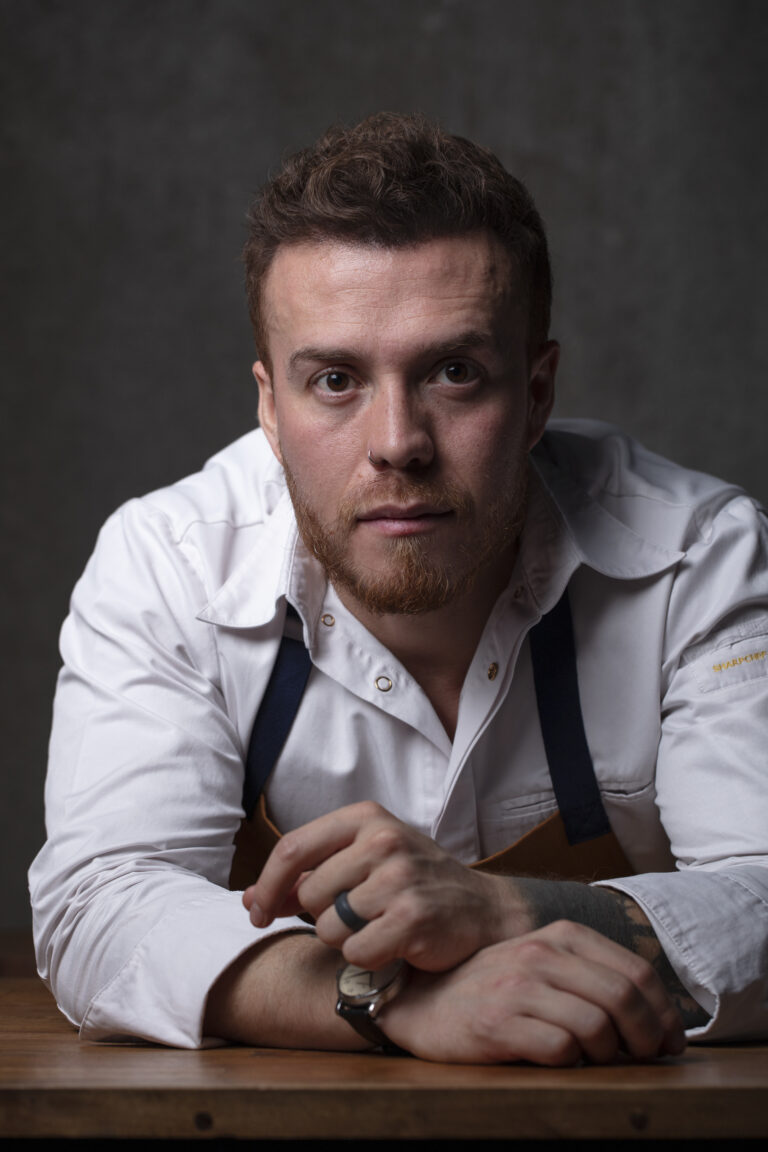 Elegant Chef Jimmy Matiz with white chef jacket and apron